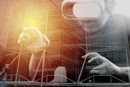 businessman wearing virtual reality goggles in modern office with Smartphone using with VR headset with London city exposureの写真素材