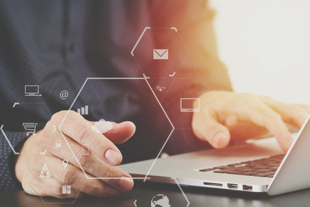 close up of businessman hand working with laptop computer in modern office with virtual icon diagram