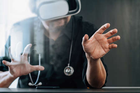 smart doctor wearing virtual reality goggles in modern office with mobile phone using with VR headsetの写真素材