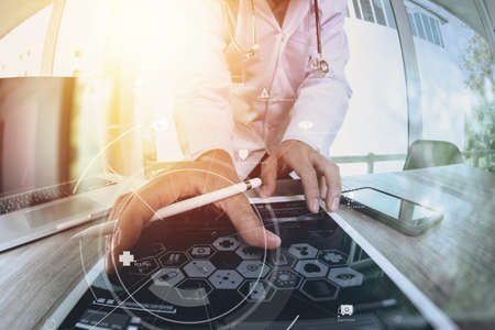 smart medical doctor working with digital tablet computer and stethoscope and mobile phone on wooden desk with virtual icon diagramの写真素材