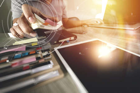 businessman working with mobile phone and digital tablet and laptop computer on wooden desk in modern office with virtual icon diagramの写真素材