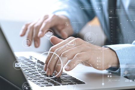 close up of businessman typing keyboard with laptop computer on wooden desk in modern office with...