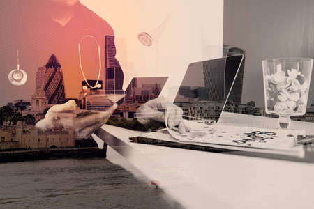 smart medical doctor working with smart phone and digital tablet and laptop computer and stethoscope on wood desk in modern office with London city exposureの写真素材