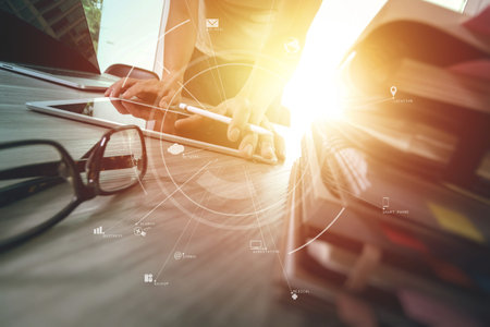 businessman working with mobile phone and digital tablet and laptop computer on wooden desk in modern office with virtual icon diagramの写真素材