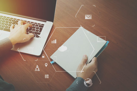 top view of  businessman hand working with laptop computer and book with VR business strategy...