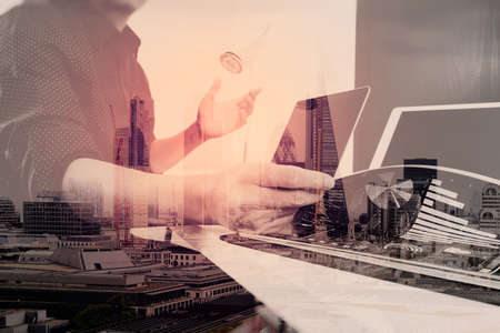 businessman working with smart phone and digital tablet and laptop computer and document in modern office with London city exposureの写真素材