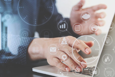 close up of businessman hand working with laptop computer in modern office with virtual icon diagram