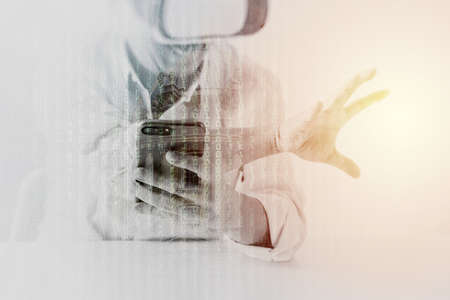 businessman wearing virtual reality goggles in modern office with Smartphone using with VR headset with metix code exposureの写真素材