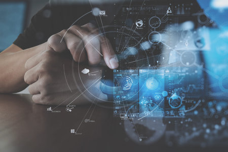 businessman hand working with smart watch computer in modern office with virtual icon diagramの写真素材