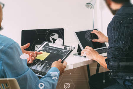 co working team meeting concept,businessman using smart phone and digital tablet and laptop computer in modern office with virtual icon graph and chartの写真素材