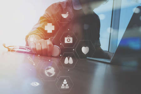 businessman working with mobile phone and digital tablet and laptop computer on wooden desk in modern office with virtual icon diagramの写真素材