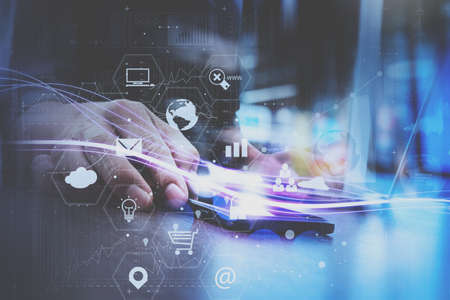 businessman hand working with mobile smart phone in modern office with virtual icon diagramの写真素材