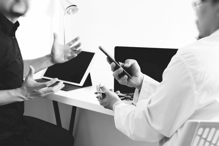 Medical doctor in white uniform gown coat consulting businessman patient having exam as Hospital...