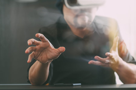 businessman wearing virtual reality goggles in modern office with mobile phone using with VR headset