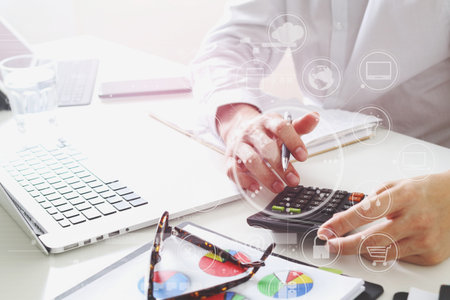 businessman hand working with finances about cost and calculator and latop with mobile phone on...