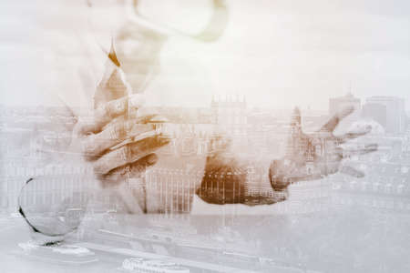businessman wearing virtual reality goggles in modern office with Smartphone using with VR headset with city exposureの写真素材