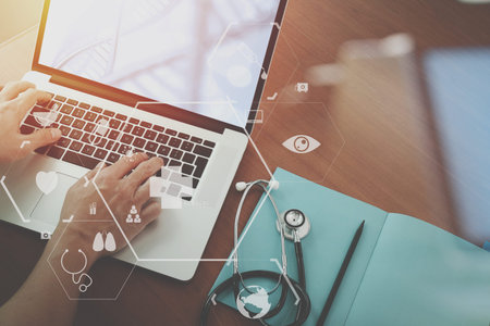 top view of smart medical doctor working with stethoscope and laptop and digital tablet computer on...