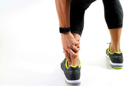Runner sportsman holding ankle in pain with Broken twisted joint running sport injury and Athletic man touching foot due to sprain on white backgroundの写真素材