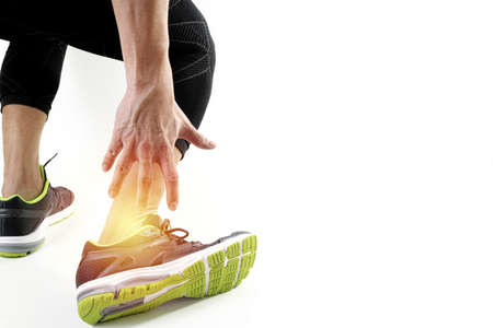 Runner sportsman holding ankle in pain with Broken twisted joint running sport injury and Athletic man touching foot due to sprain on white backgroundの写真素材