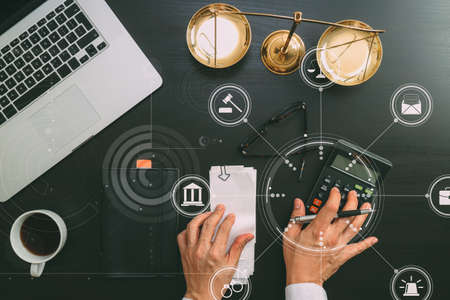 justice and law concept.businessman or lawyer or accountant working on accounts using a calculator and laptop computer and documents with Vr diagramの写真素材