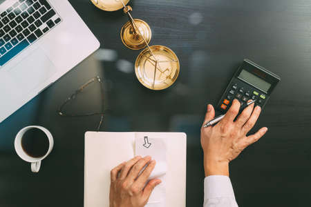 Justice and law concept.businessman or lawyer or accountant working on accounts using a calculator and laptop computer and documents in modern officeの写真素材