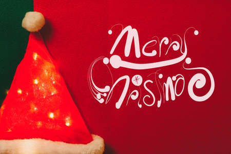 Greeting Season concept.Santa Claus hat with christmas light on red and green backgroundの写真素材