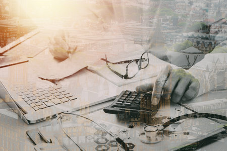 Healthcare costs and fees concept.Hand of smart doctor used a calculator for medical costs in modern hospital with city exposureの写真素材