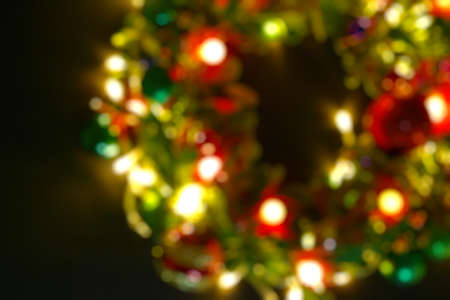 Greeting Season concept.Blur Christmas wreath with decorative light on dark wood backgroundの写真素材