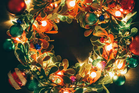 Greeting Season concept.Christmas wreath with decorative light on dark wood backgroundの写真素材