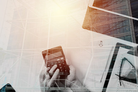 top view of businessman hand working with finances about cost and calculator and latop with mobile...