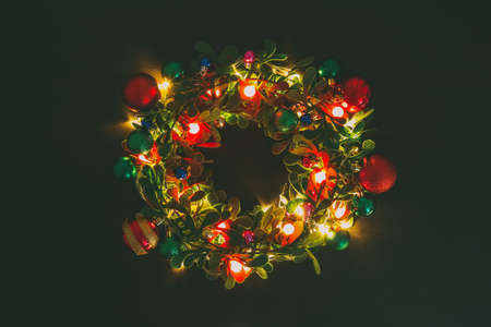 Greeting Season concept.Christmas wreath with decorative light on dark wood backgroundの写真素材