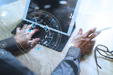 businessman hand working with modern laptop computer in modern office with virtual icon diagram