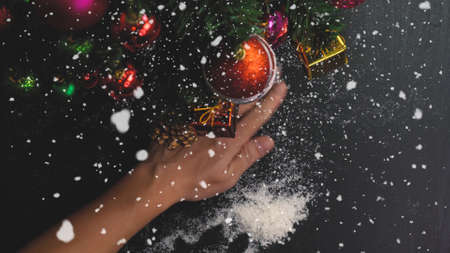 Greeting Season concept.hand setting of ornaments on a Christmas tree with decorative lightの写真素材