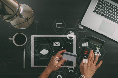 Internet shopping concept.Top view of hands working with laptop and credit card and tablet computer...