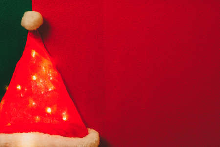 Greeting Season concept.Santa Claus hat with christmas light on red and green backgroundの写真素材