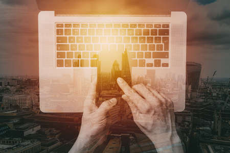 cyber security internet and networking concept.Businessman hand working with VR screen padlock icon mobile phone on laptop computer background with buildings exposureの写真素材