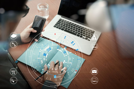 close up of businessman working with smart phone and digital tablet and laptop computer  on wooden...