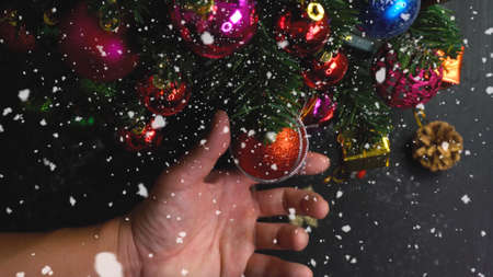Greeting Season concept.hand setting of ornaments on a Christmas tree with decorative lightの写真素材