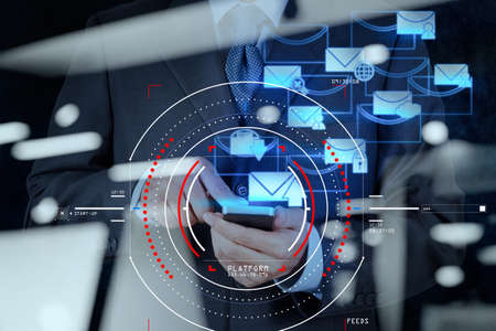 Concept of focus on target with digital diagram,graph interfaces,virtual UI screen,connections netwoork.businessman working with E-mail and smart phoneの写真素材