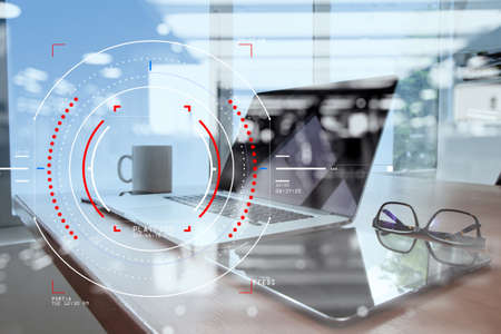 Concept of focus on target with digital diagram,graph interfaces,virtual UI screen,connections netwoork.Workspace of excusive office in modern buildingの写真素材