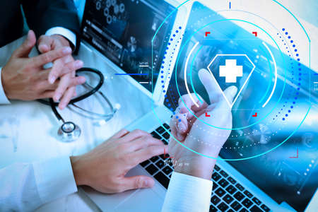 Health care and medical services with circular AR diagram.Medical technology network team meeting concept. Doctor hand working smart phone modern digital tablet laptop computer の写真素材