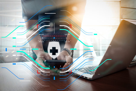 Health protection. Medical and health care concept.designer hand working and smart phone and laptop on wooden desk in office with london city background     の写真素材