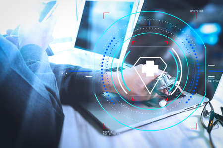 Health care and medical services with circular AR diagram.Medicine doctor hand working with modern digital tablet and laptop computer の写真素材