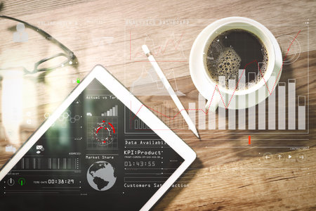 Intelligence (BI) and business analytics (BA) with key performance indicators (KPI) dashboard concept.Coffee cup and Digital table dock smart keyboard,eyeglasses,stylus pen on wooden tableの写真素材