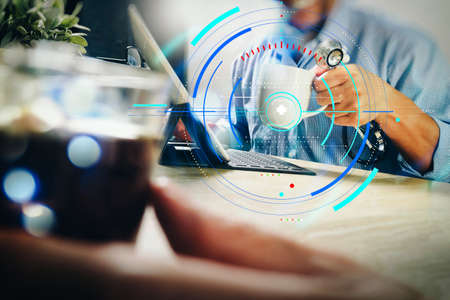 Health care and medical services with circular AR diagram record.Medical doctor team taking coffee break.using digital tablet docking smart keyboard and smart phone on marble desk.の写真素材