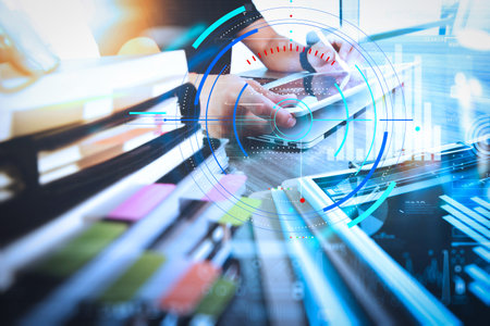 Data statistics charts and key performance indicators diagram.designer hand working with digital tablet and laptop computer and book stack and eye glass on wooden desk as conceptの写真素材