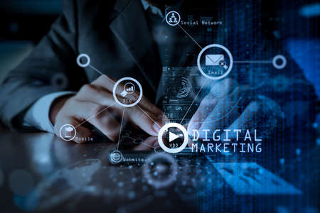 Digital marketing media (website ad, email, social network, SEO, video, mobile app) in virtual screen.Businessman hand using mobile phone with digital layer effect as business strategy concept.の写真素材