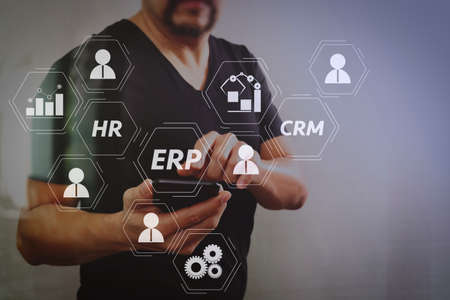 Architecture of ERP (Enterprise Resource Planning) system with connections between business intelligence (BI), production, CRM modules and HR diagram.Designer hand using smart phone for mobile payments online.の写真素材