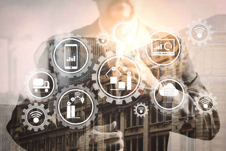 Smart factory and industry 4.0 and connected production robots exchanging data with internet of things (IoT) with cloud computing technology.success businessman holding neck tie with London building.の写真素材