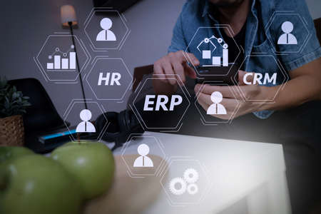 Architecture of ERP (Enterprise Resource Planning) system with connections between business intelligence (BI), production, CRM modules and HR diagram.young man is sitting on sofa shopping on line with smart phone.の写真素材